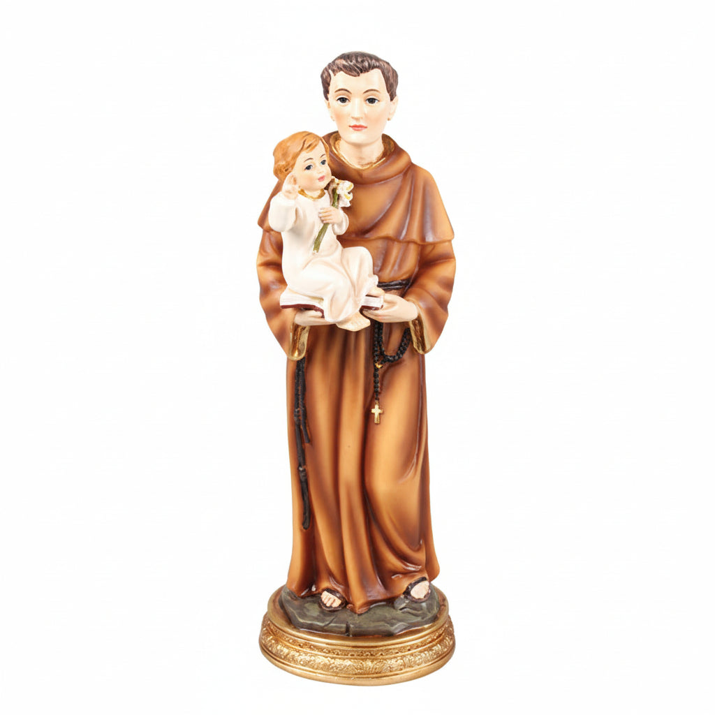 A resin statue of Saint Anthony holding a child, with a gold-colored halo and robe, standing on a base.