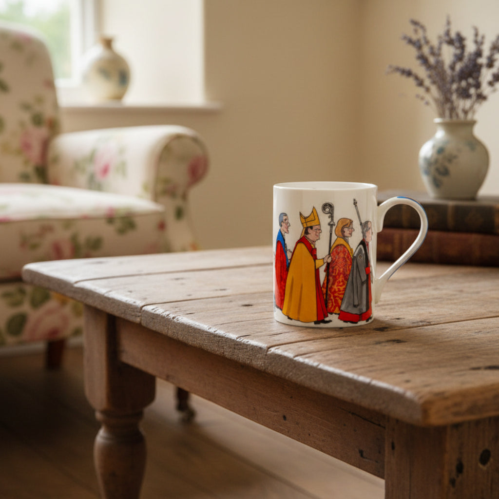A white fine bone china mug with a colorful illustration of a cathedral procession, featuring characters in historical clothing and a king with a crown.