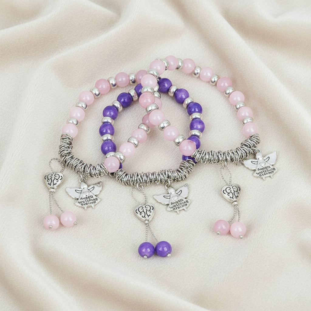 Set of pink and purple beaded bracelets with silver charms on a dark background