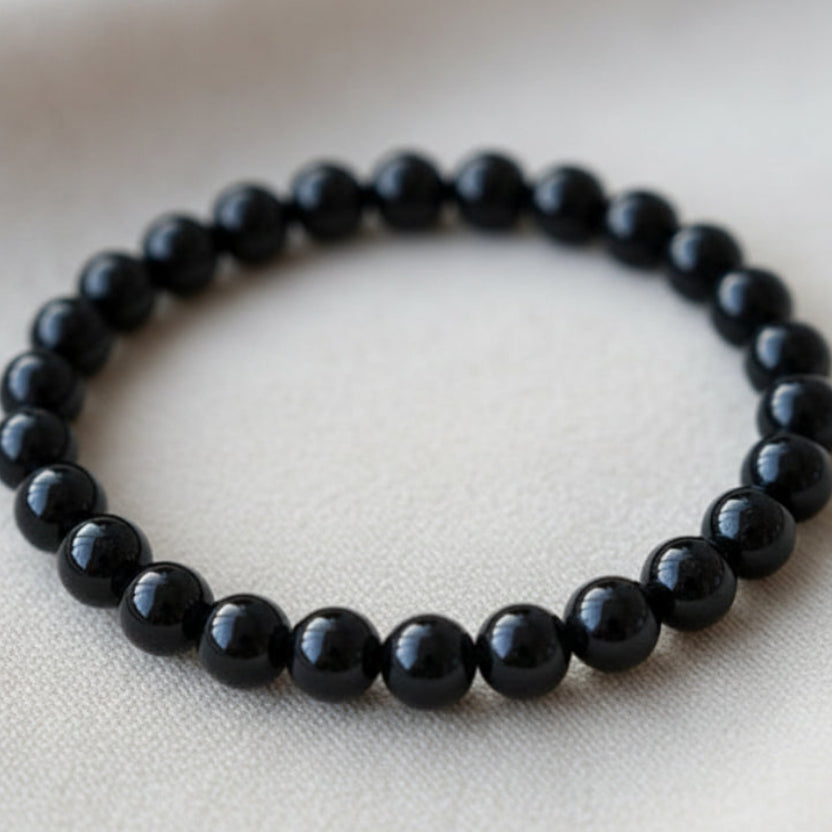 Black agate power bracelet on a beige card with text