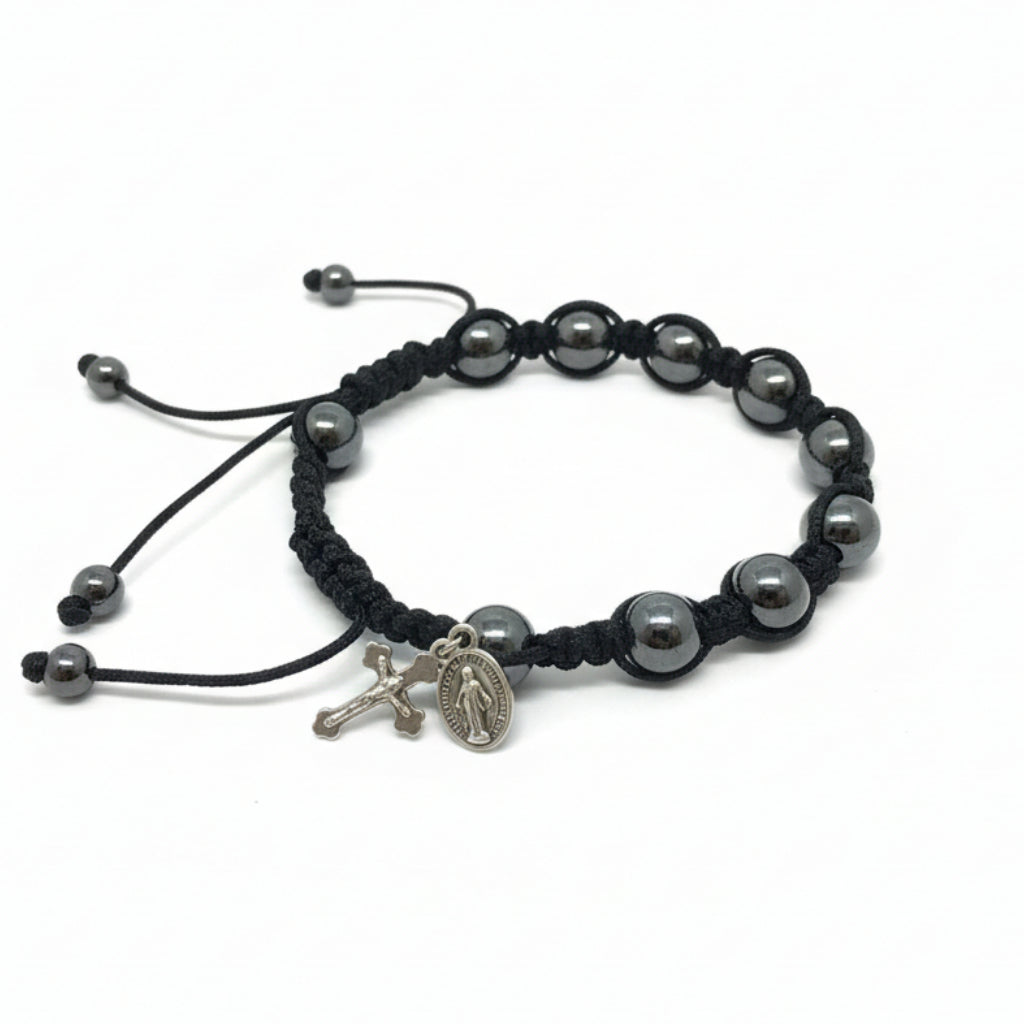 Black beaded bracelet with a charm on a white paper background