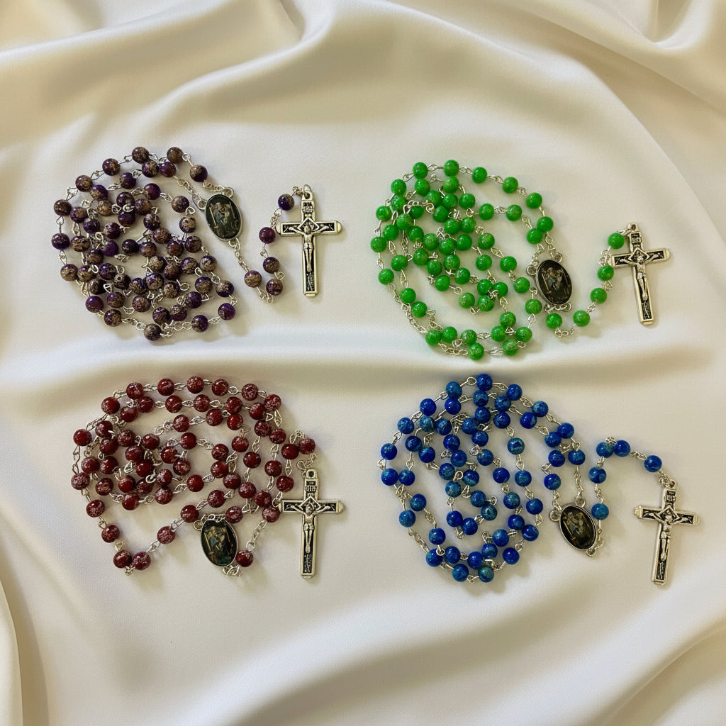 Four rosaries with different colored beads on a white background
