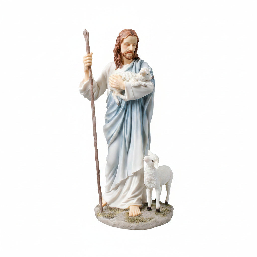 A religious figurine of Jesus holding a white lamb, standing next to a small white lamb and holding a wooden staff, set against a plain white background.