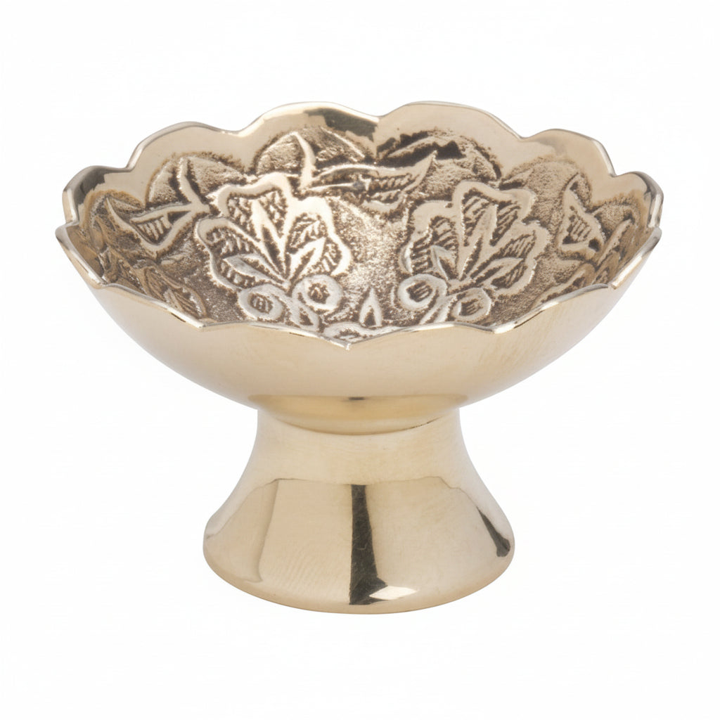 Decorative brass bowl with intricate patterns on a white background