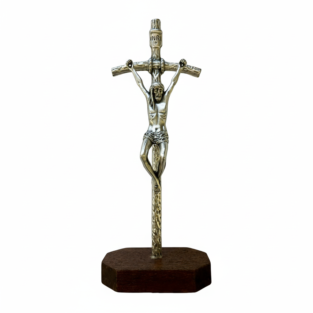 A metal standing crucifix with a wood base, depicting Jesus Christ on the cross.