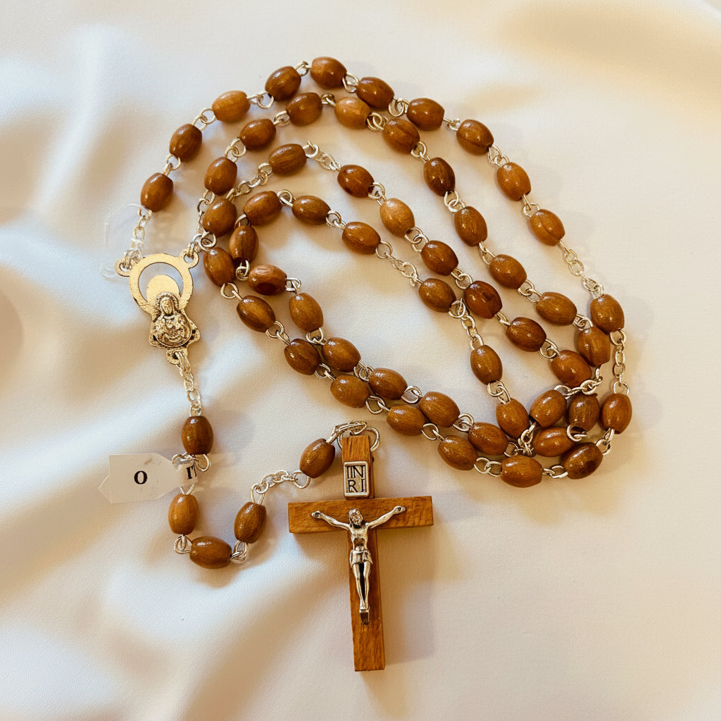 A rosary made of olive wood beads with a silver chain and a wooden cross featuring an image of Jesus Christ in the center.