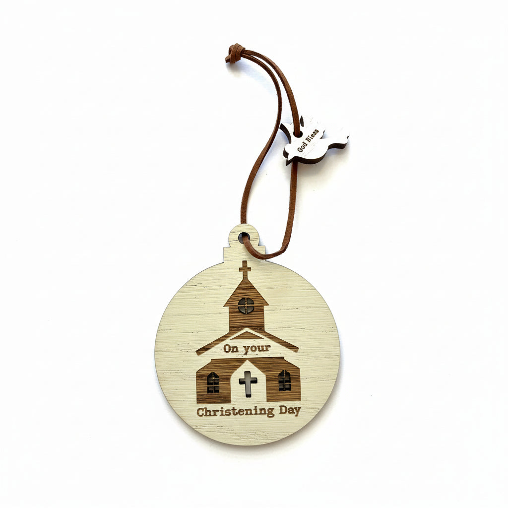 A wooden decoration for christenings, featuring a circular shape with an illustration of a church and a cross, and the text 'On your Christening Day'. There is a small heart-shaped tag with a bird silhouette on it.