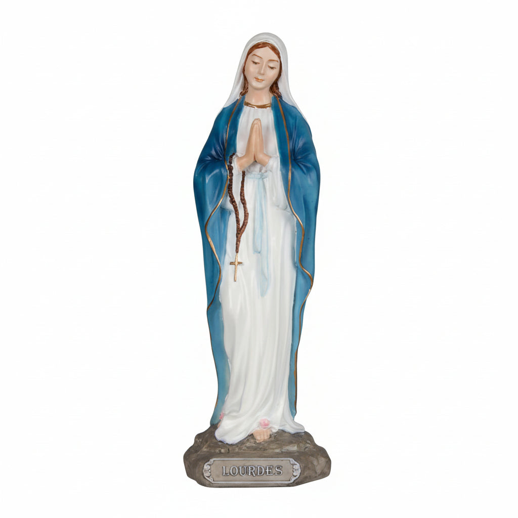 A resin statue of Our Lady of Lourdes, featuring the Virgin Mary in a blue and white dress with a rosary and a label indicating the artist and brand.