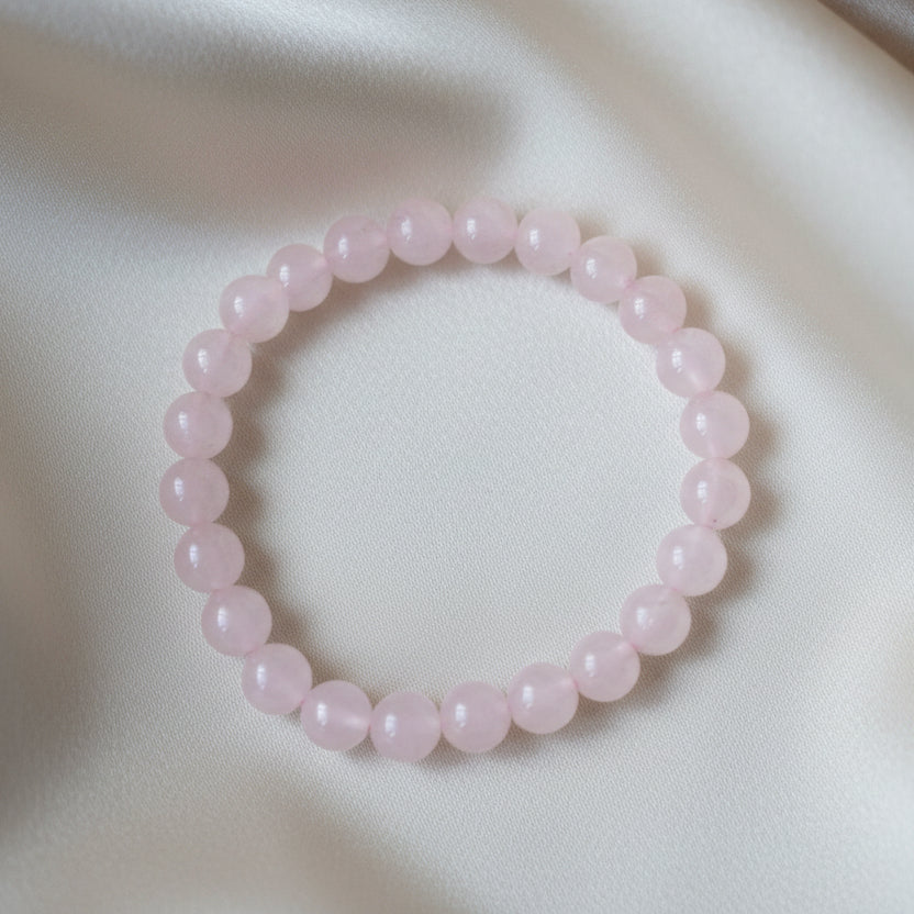Rose quartz power bracelet on a wooden surface with a label
