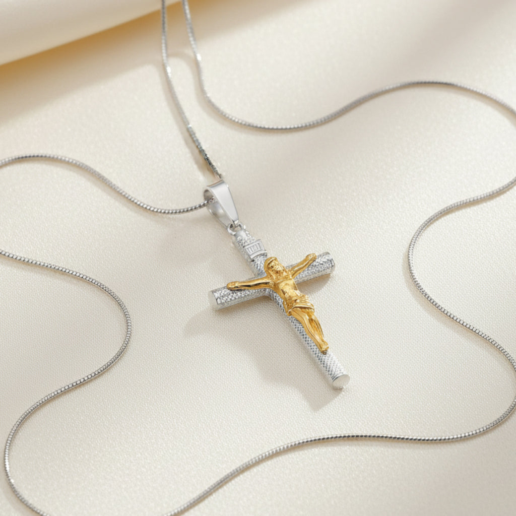 Two-tone cross pendant with Jesus figure on a white background