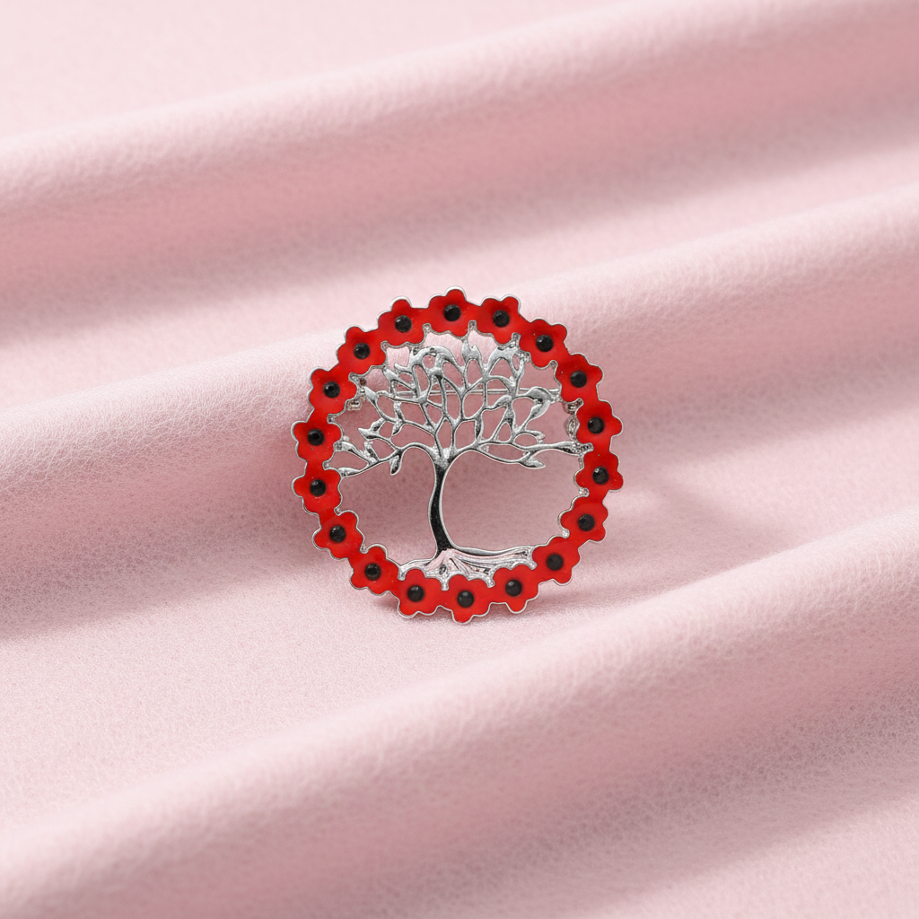 A silver brooch in the shape of a tree of life with a poppy wreath design, featuring red enamel and jet crystals.