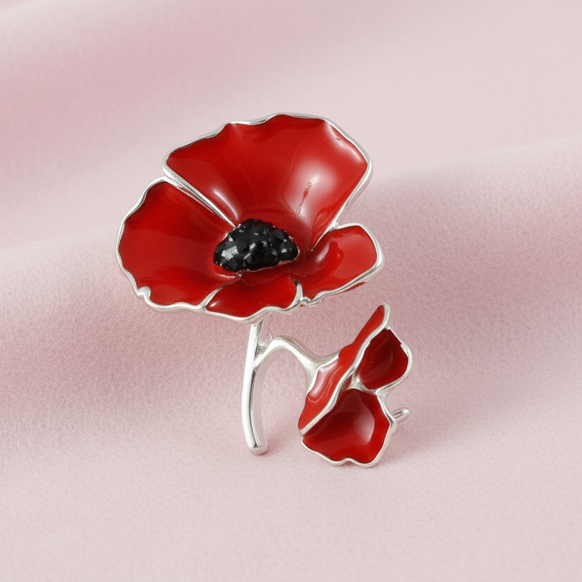 A red poppy brooch with two stems and jet crystals in the center, set on a white background.