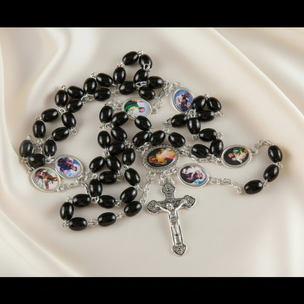 Black rosary with colorful images on black beads on a white fabric background
