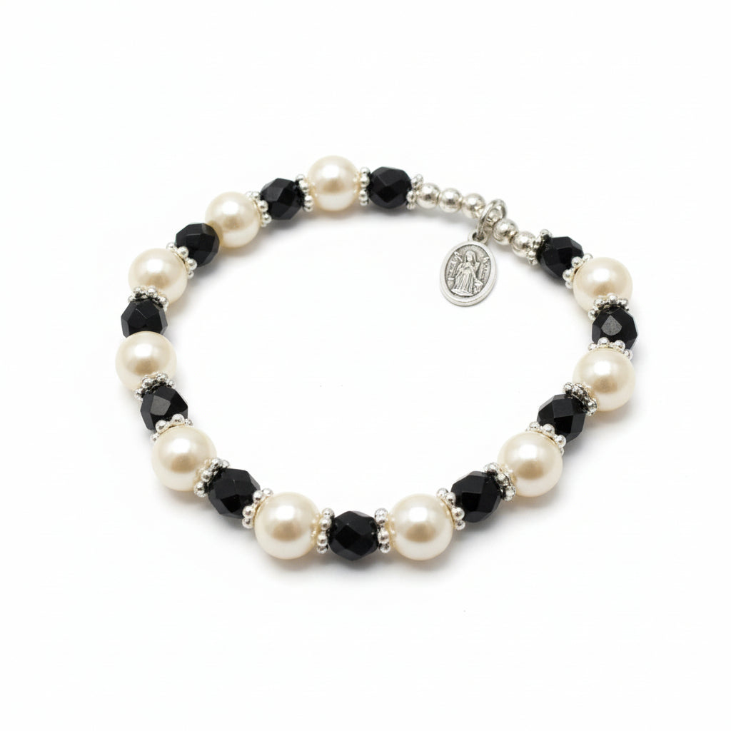 Pearl and black bead bracelet on a white surface