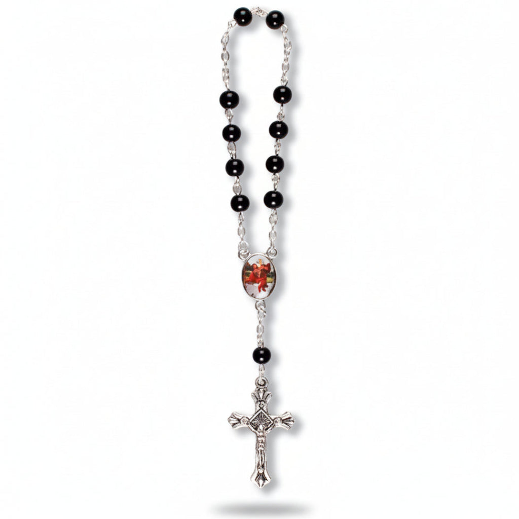 A single decade car rosary with black glass beads, a silver-colored cross, and a red heart-shaped bead.