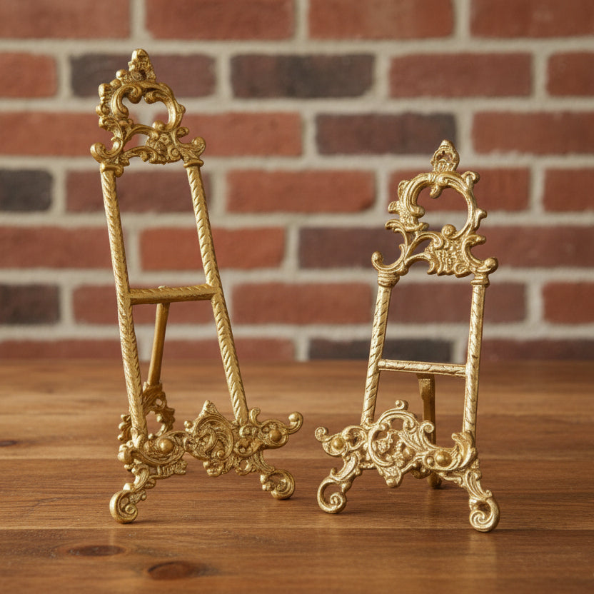 Two gold-colored brass icon easels with intricate designs and ornamental details.