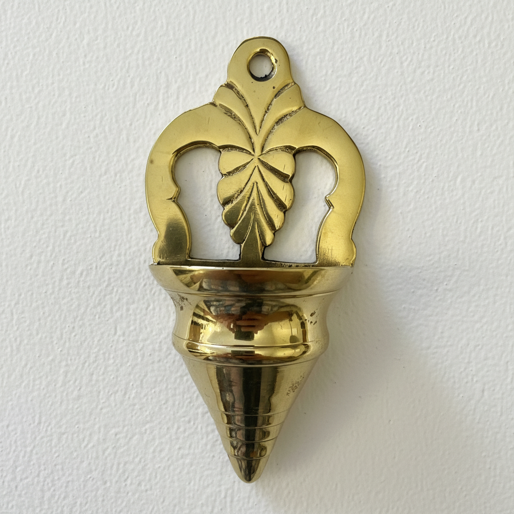 A brass hanging wall font with a leaf-like design at the top, intended for use as a religious item.