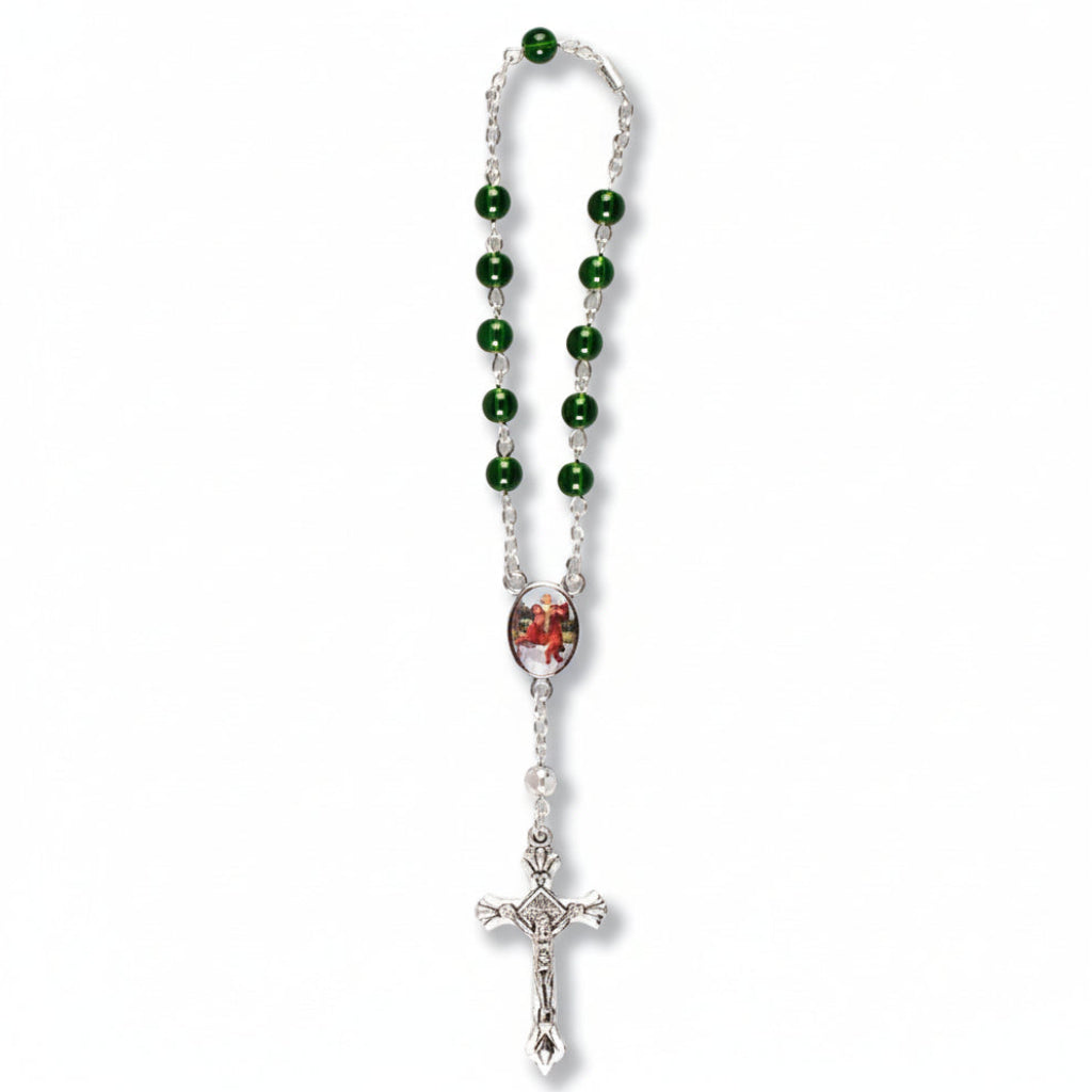 A green glass car rosary with a metal clasp, packaged in a clear plastic header card with 'Ora' and 'Vale' text on it.