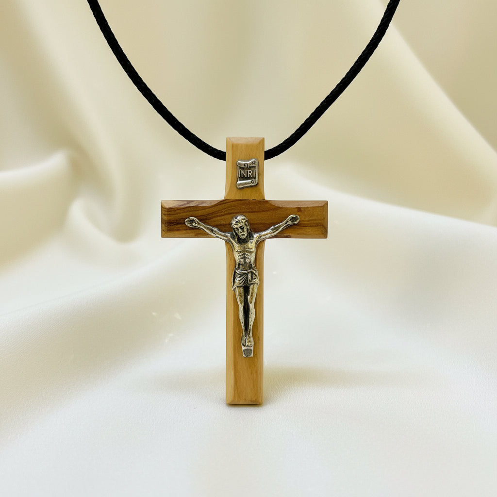An olivewood cross necklace in packaging, with the text 'Olive Wood' and 'Hand Made In The Holy Land' displayed.