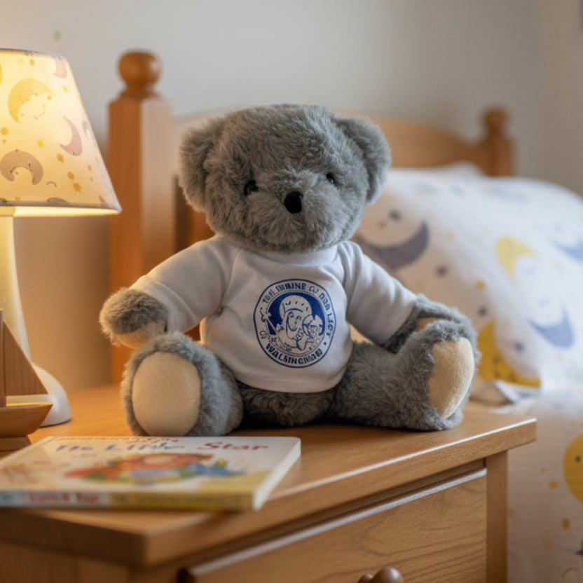 Gray teddy bear wearing a white shirt with a logo on a white background
