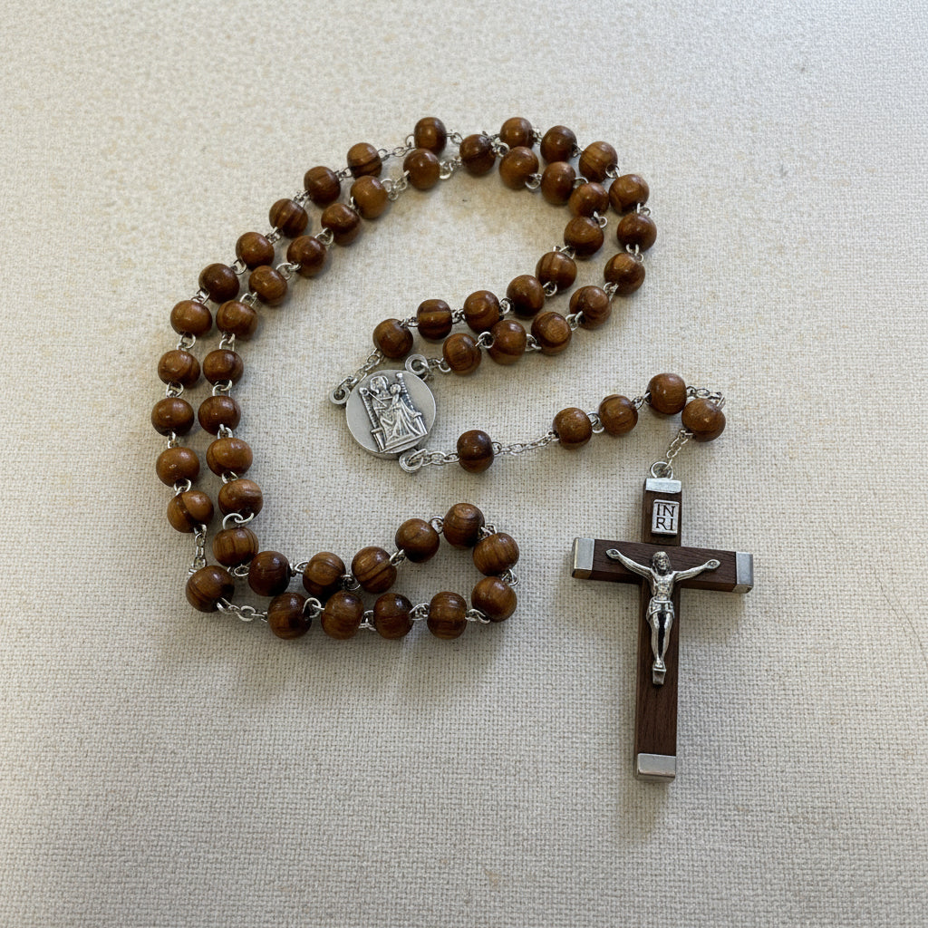 Wooden rosary with brown beads and crucifix on a beige background