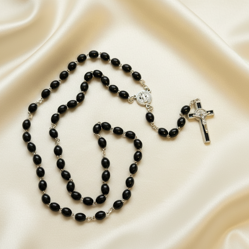 A black and gold colored rosary with a cross and a center piece, displayed against a black background.