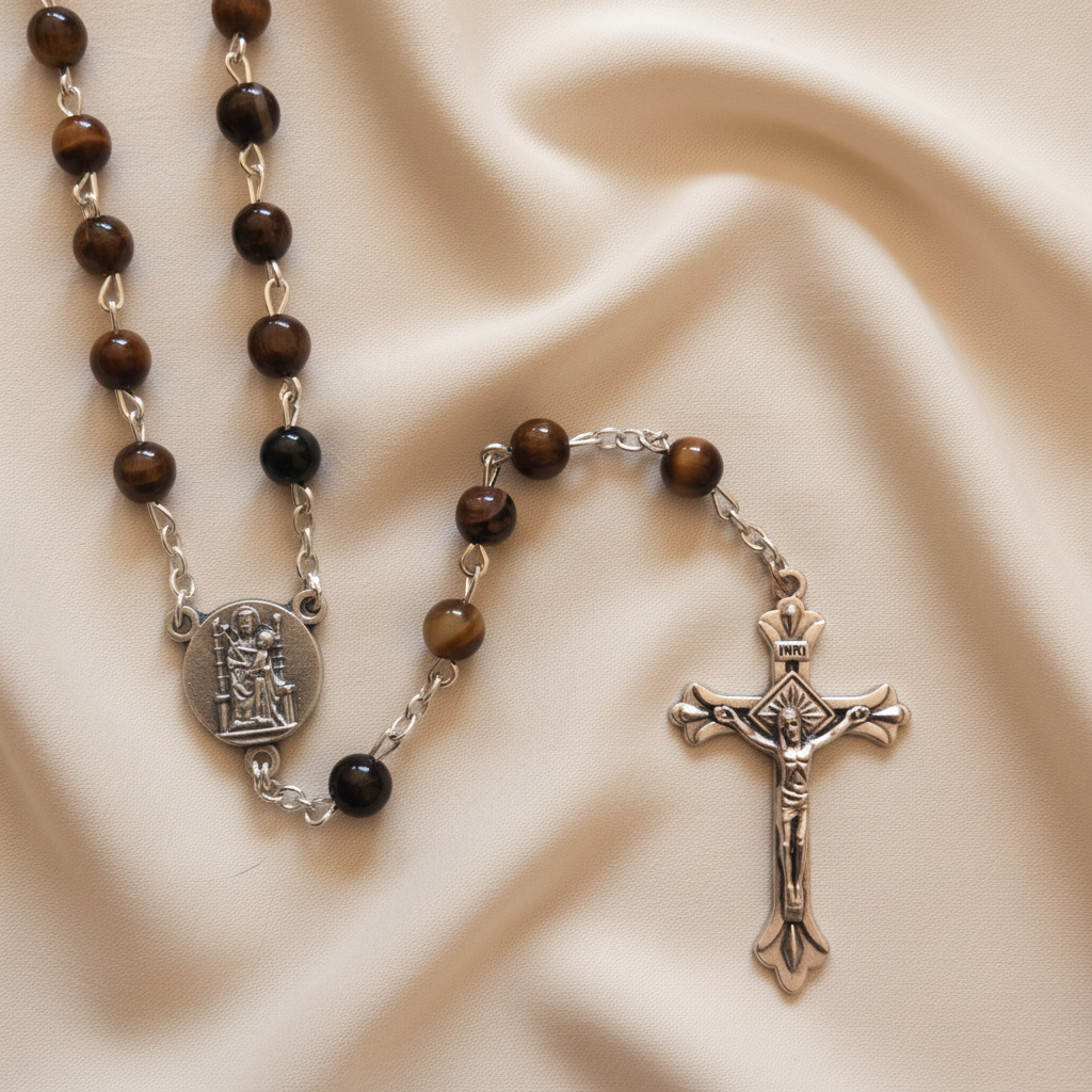 A Tiger's Eye rosary with ornate metal beads and a metal crucifix.