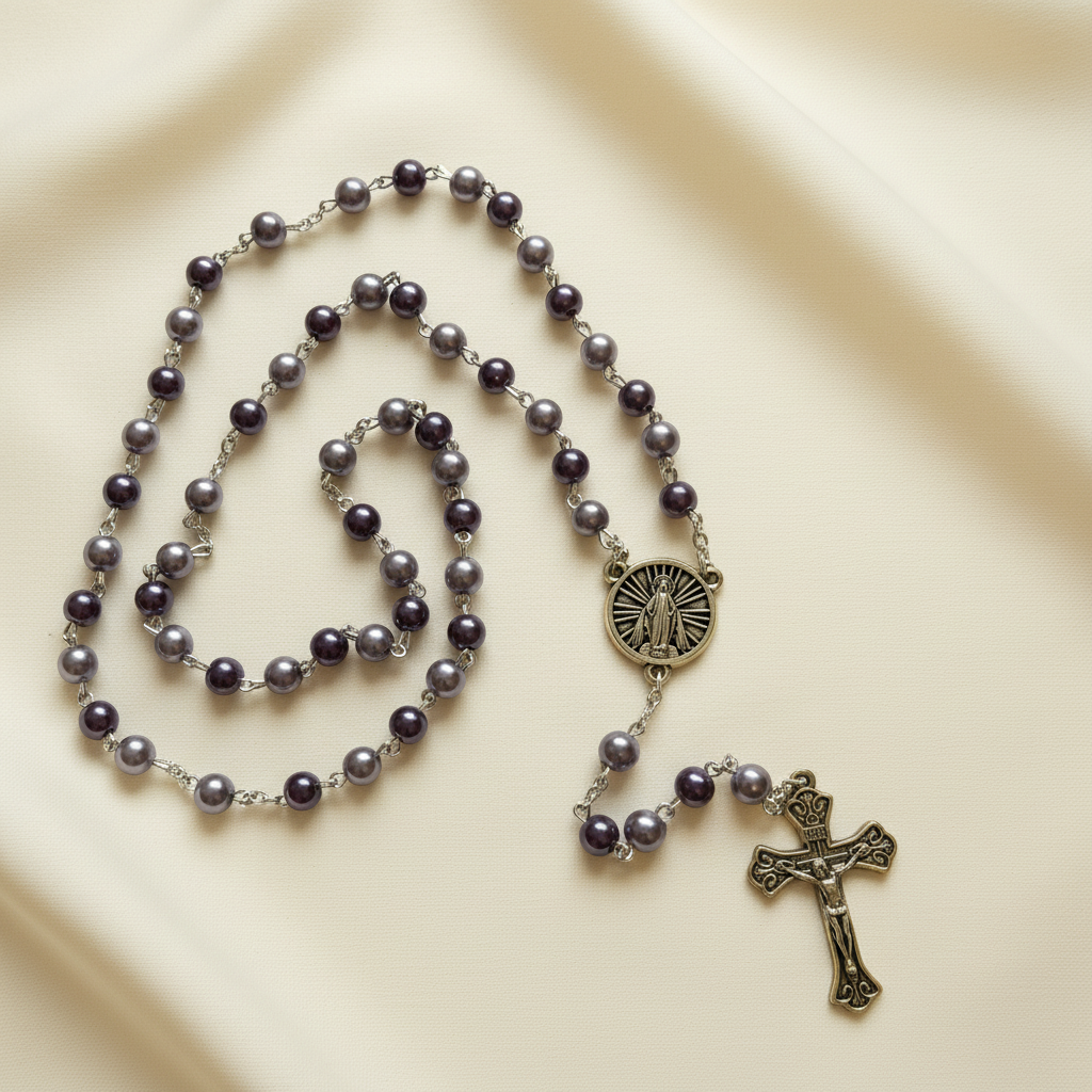 A lilac-colored rosary with a mix of bead types and a crucifix emblem in the center.
