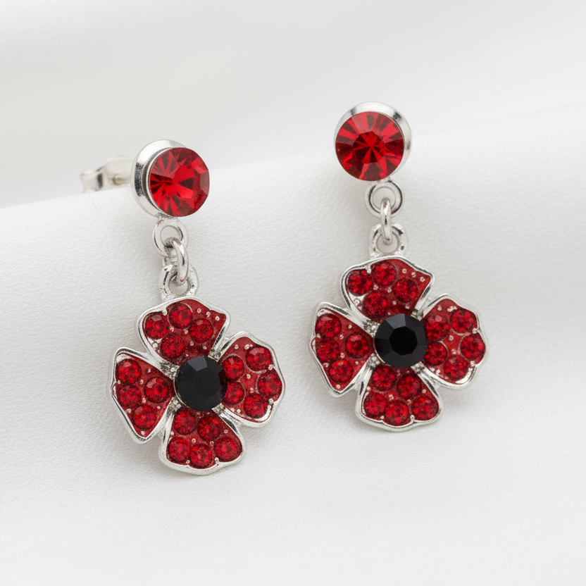 A pair of red and silver poppy-shaped drop earrings with a studs backs, presented in a box.