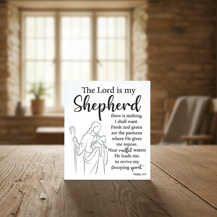 A ceramic plaque with embossed text that reads 'The Lord is My Shepherd', alongside a small illustration of a shepherd carrying a sheep. The background is plain.