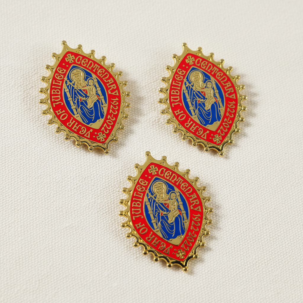A set of enamel pilgrim badges with a religious theme, featuring colors gold, blue, and red, and a central emblem with a figure and text.